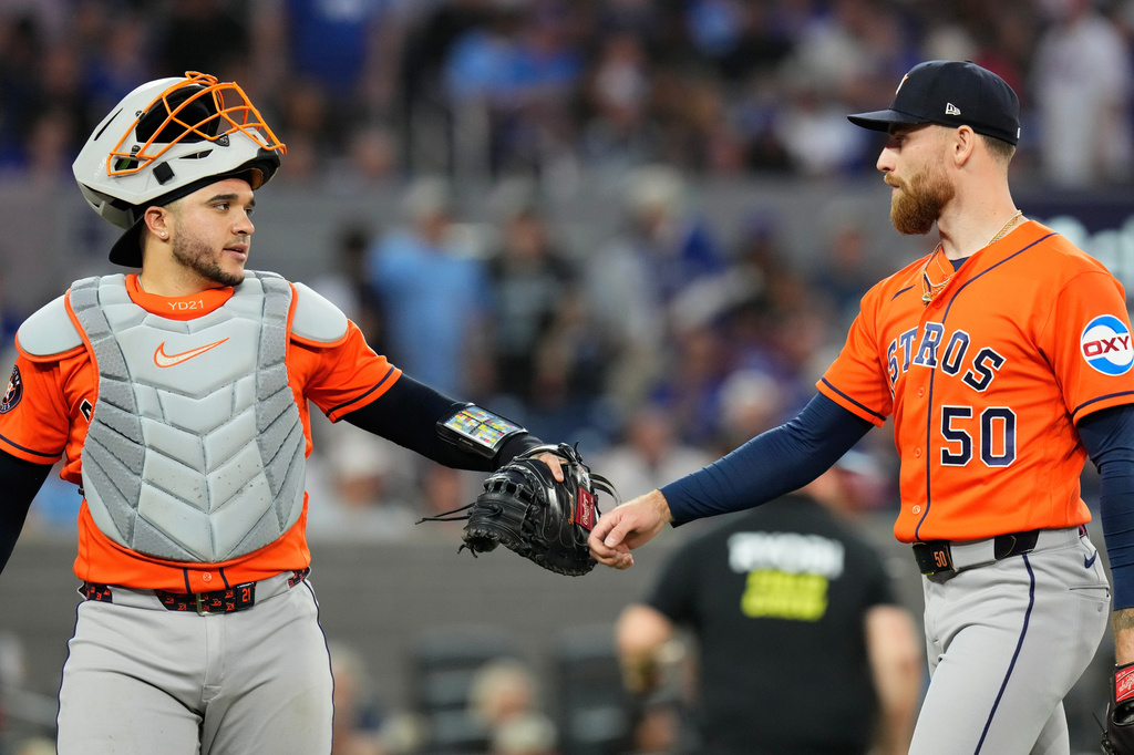 Houston Astros catcher Yainer Diaz (21) congratulated Astros pitcher Mike Burrows (50) after Toronto Blue Jays Vladimir Guerrero Jr. lined out to end sixth inning of a baseball game in Toronto on Wednesday, June 24, 2026. (Chris Young/The Canadian Press via AP)