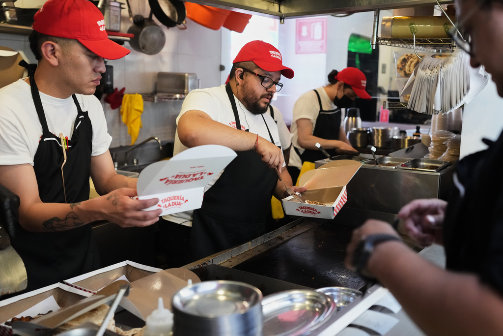Workers prepare tacos at the opening of Dua Lipa's taqueria, a pop-up restaurant for her fans in Mexico City, Monday, Dec. 1, 2025. (AP Photo/Eduardo Verdugo)