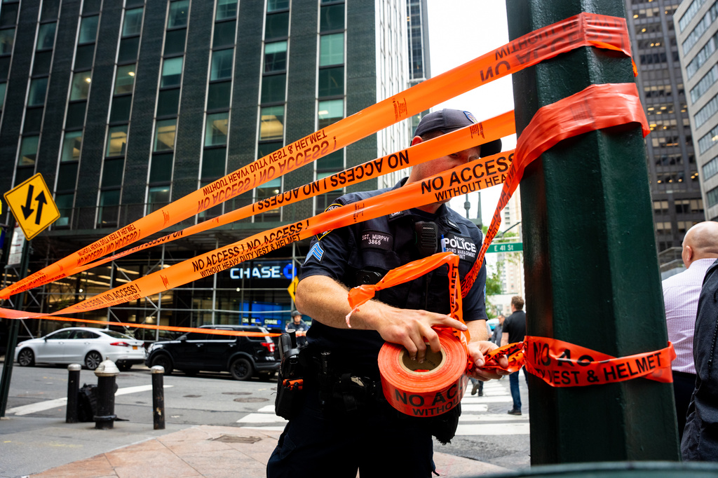 An NYPD officer puts up caution tape near East 41st Street after buildings in the area were evacuated, Tuesday, July 7, 2026, in New York. (AP Photo/Angelina Katsanis)
