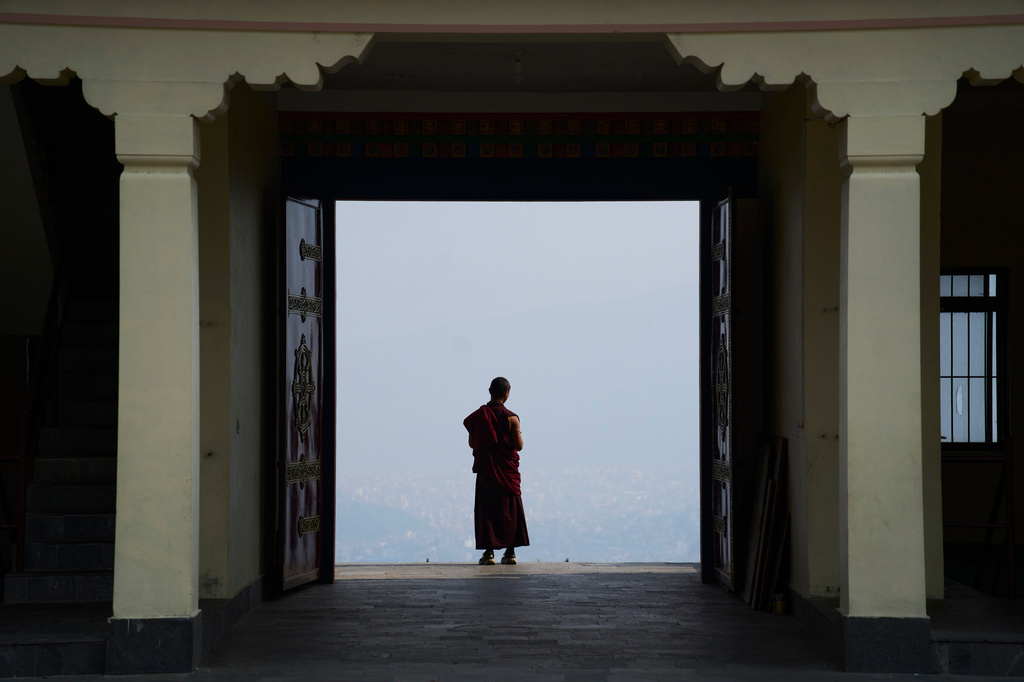 A Buddhist monk takes a break from a ritual at Dzarong Thubten Mindrol Dongä Monastery in Kathmandu, Nepal, Tuesday, April 14, 2026. (AP Photo/Niranjan Shrestha)
