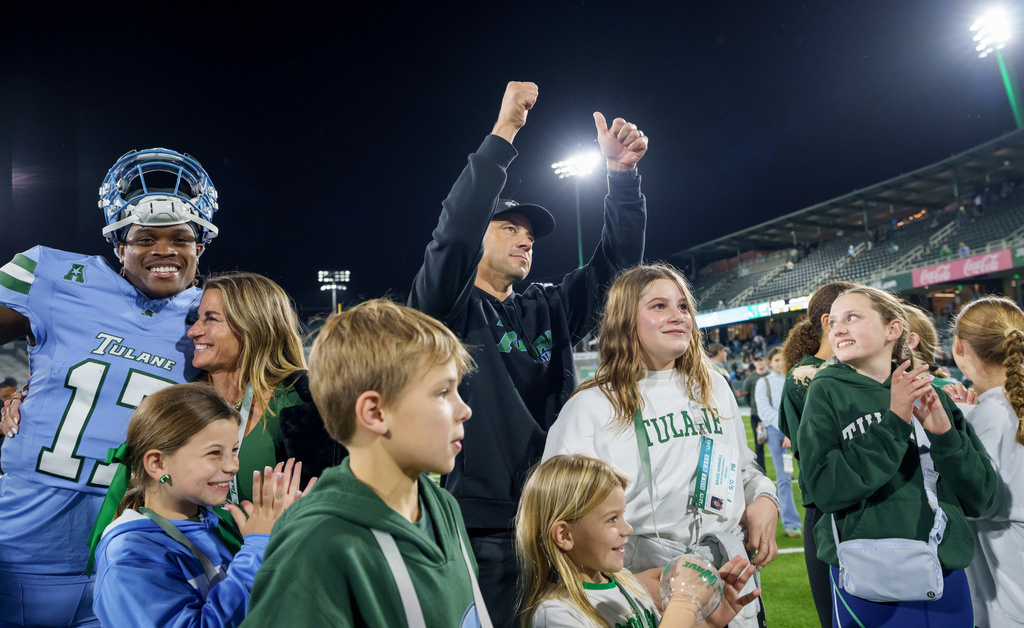 Tulane head coach Jon Sumrall, center, celebrates at the end of an NCAA college football game against Charlotte with his family and players in New Orleans, Saturday, Nov. 29, 2025. (AP Photo/Matthew Hinton)