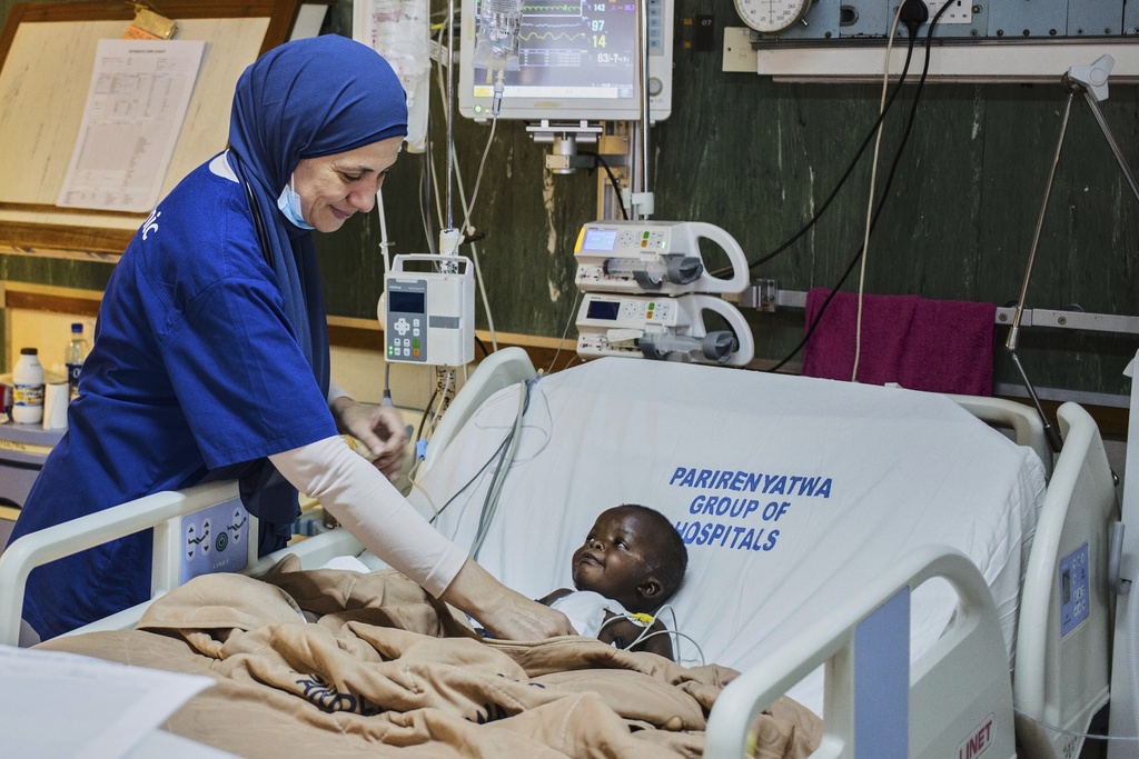 A doctor checks on a Anashe Mugoba as she recovers from an open-heart surgery at Parirenyatwa Hospital, Harare, Zimbabwe, Thursday, July 17, 2025. (AP Photo/Aaron Ufumeli)