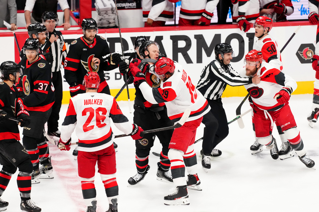 Ottawa Senators left wing Brady Tkachuk, center left, and Carolina Hurricanes defenseman K'andre Miller (19) fight during the second period of Game 4 in a first-round NHL hockey Stanley Cup playoff series in Ottawa, Ontario, Saturday, April 25, 2026. (Sean Kilpatrick/The Canadian Press via AP)