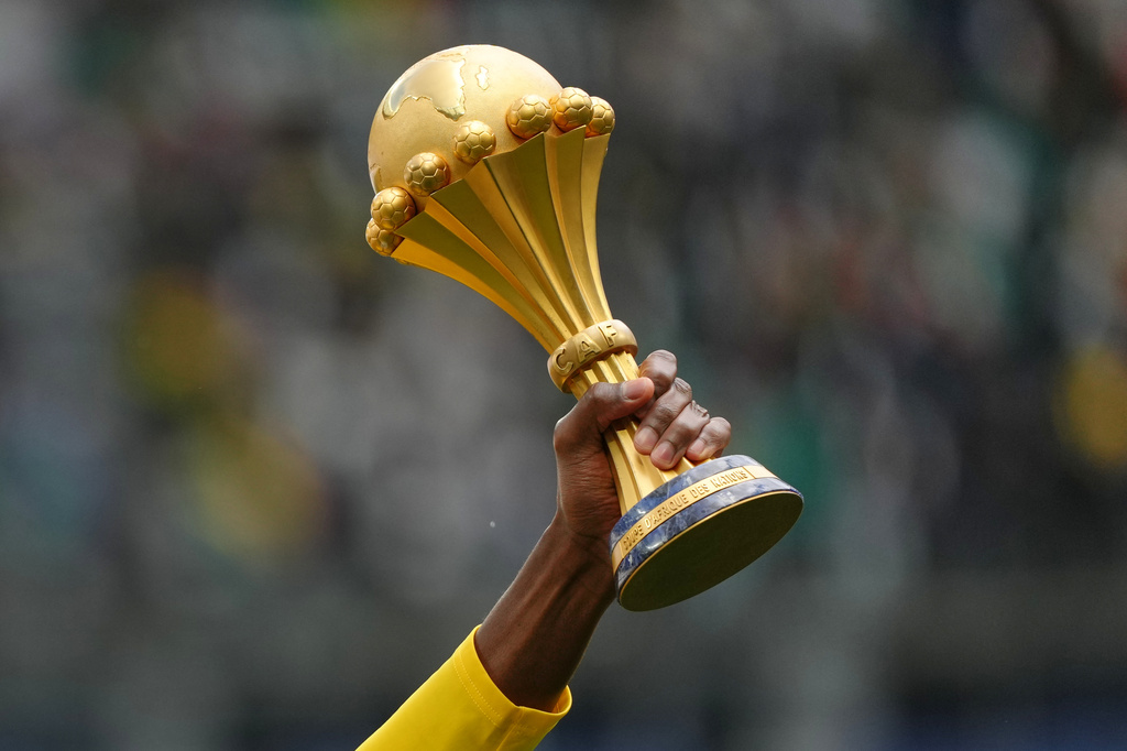 A Senegal player holds the Africa Cup of Nations trophy ahead of the international friendly soccer match between Senegal and Peru in Saint-Denis, outside of Paris, Saturday, March 28, 2026. (AP Photo/Aurelien Morissard)
