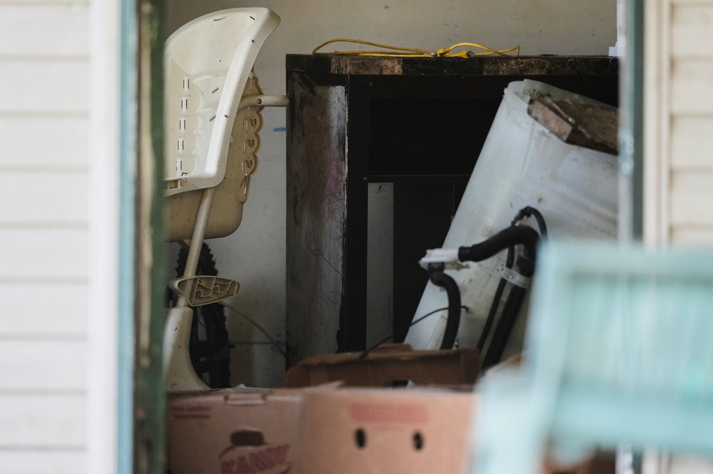 Items including a high chair, left, are seen in a home where authorities say they removed 16 children and arrested four adults in Hamden, Ohio, Wednesday, July 1, 2026. (AP Photo/Carolyn Kaster)