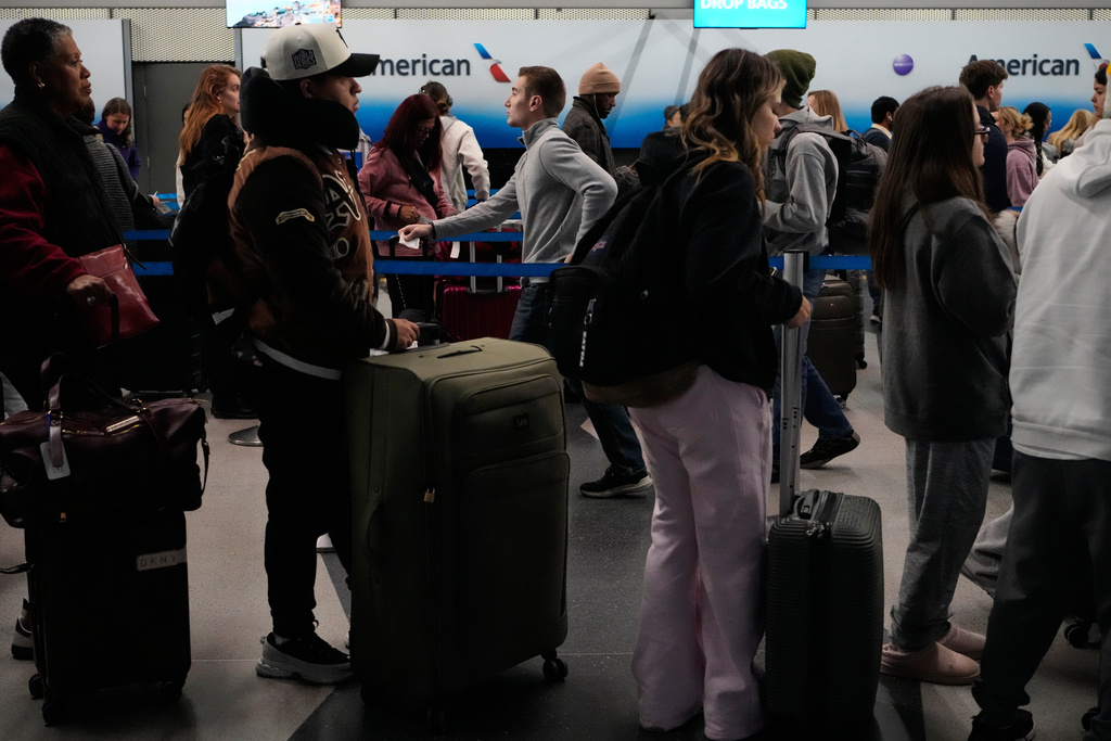 Travelers line up to check their tickets at O'Hare International Airport in Chicago, Wednesday, Nov. 12, 2025. (AP Photo/Nam Y. Huh)