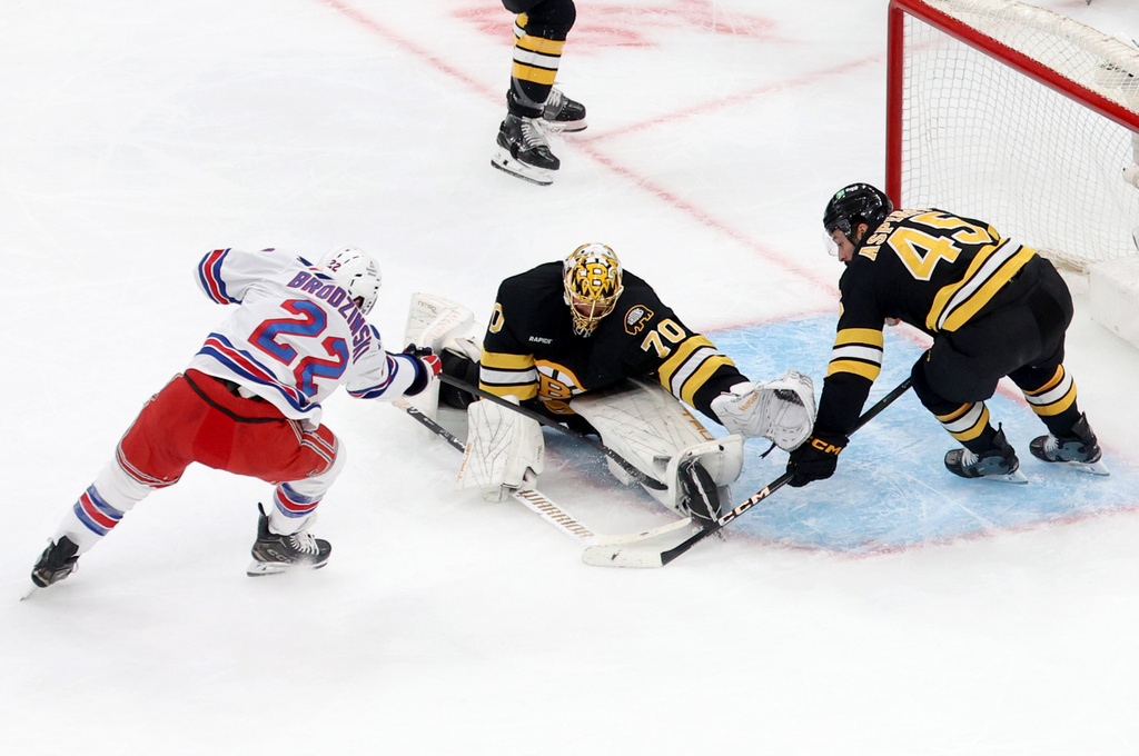 Boston Bruins goaltender Joonas Korpisalo (70) and Boston Bruins defenseman Jonathan Aspirot (45) defend the net on a goal attempt by New York Rangers center Jonny Brodzinski (22) during the second period of an NHL hockey game, Friday, Nov. 28, 2025, in Boston. (AP Photo/Mark Stockwell)