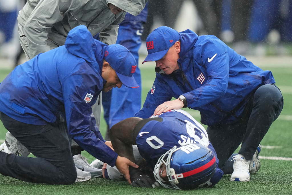 New York Giants linebacker Brian Burns (0) is assisted by the team's medical staff after being injured during the second half of an NFL football game against the Tennessee Titans in East Rutherford, N.J., Sunday, Sept. 27, 2026. (AP Photo/Frank Franklin II)