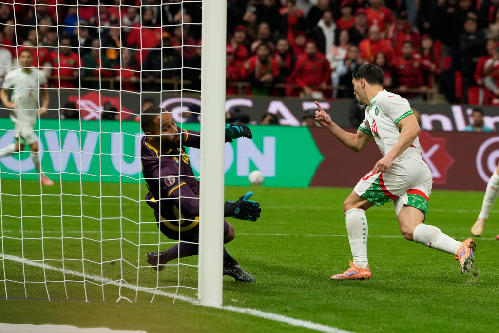Morocco's Brahim Abdelkader Díaz, right, scores his side's opening goal during the Africa Cup of Nations quarterfinal soccer match between Cameroon and Morocco, in Rabat, Morocco, Friday, Jan. 9, 2026. (AP Photo/Mosa'ab Elshamy)