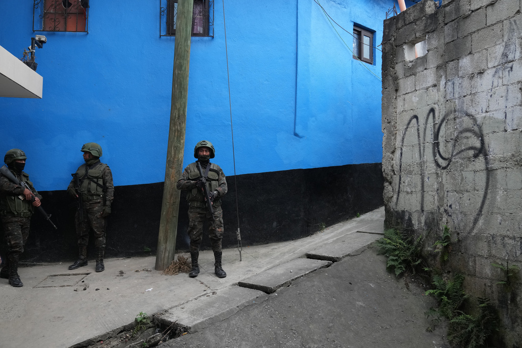 Soldiers patrol an area next to a piece of graffiti referring to the Mara Salvatrucha gang during the country's state of emergency, following an escalation of gang-related violence, on the outskirts of Guatemala City, Tuesday, Jan. 20, 2026. (AP Photo/Moises Castillo)