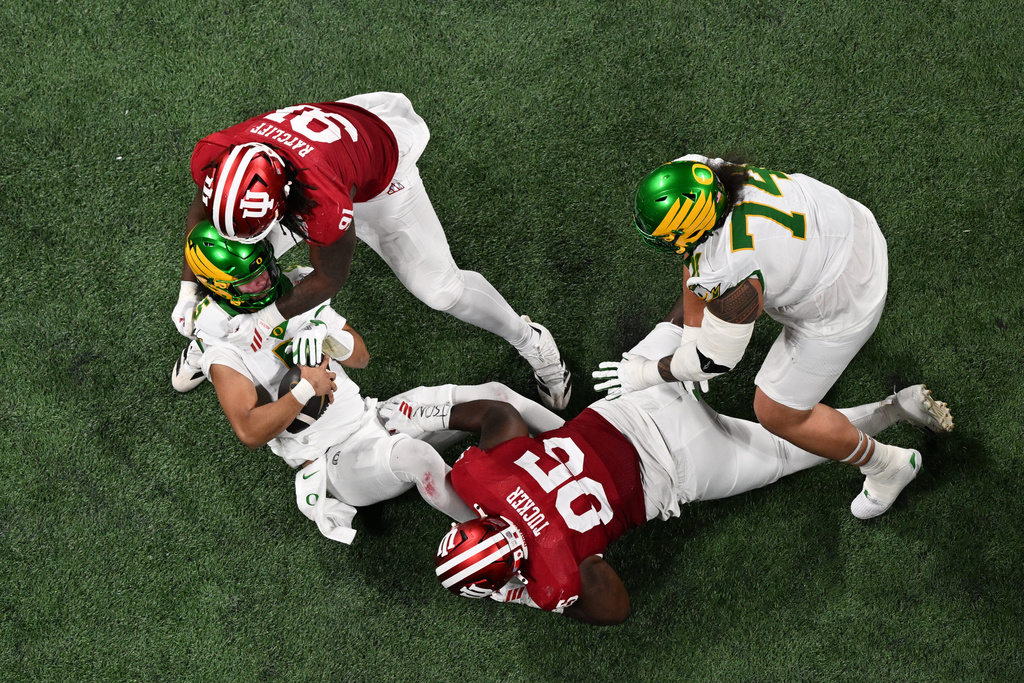 Oregon quarterback Dante Moore (5) is sacked by Indiana defensive lineman Dominique Ratcliff (91) during the first half of the Peach Bowl NCAA college football playoff semifinal, Friday, Jan. 9, 2026, in Atlanta. (AP Photo/Danny Karnik)