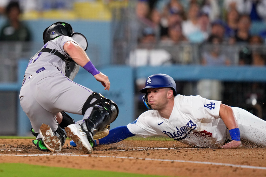 Los Angeles Dodgers' Dalton Rushing, right, is tagged out by Colorado Rockies catcher Braxton Fulford as he tries to score on a fielder's choice bunt by Miguel Rojas during the fifth inning of a baseball game Tuesday, July 7, 2026, in Los Angeles. (AP Photo/Mark J. Terrill)