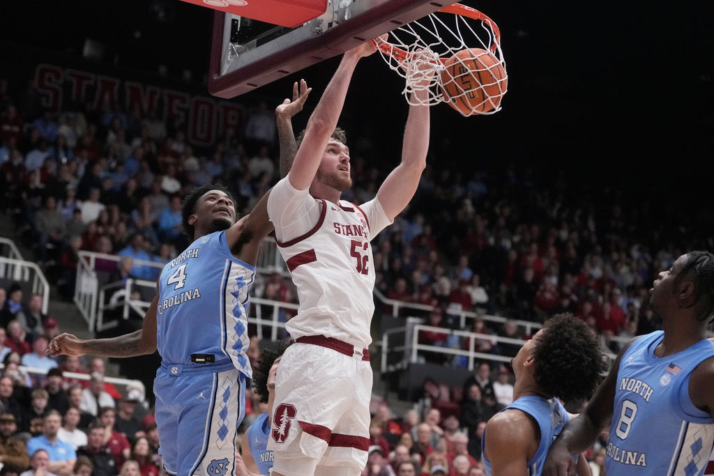 Stanford forward Aidan Cammann, middle, dunks against North Carolina guard Jaydon Young (4) during the first half of an NCAA college basketball game in Stanford, Calif., Wednesday, Jan. 14, 2026. (AP Photo/Jeff Chiu)
