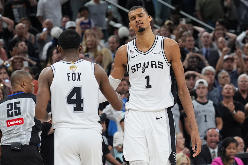 San Antonio Spurs forward Victor Wembanyama (1) and guard De'aaron Fox (4) reacts after a foul call during the second half of Game 2 of the NBA Finals basketball series against the New York Knicks, Friday, June 5, 2026, in San Antonio. (AP Photo/Eric Gay)