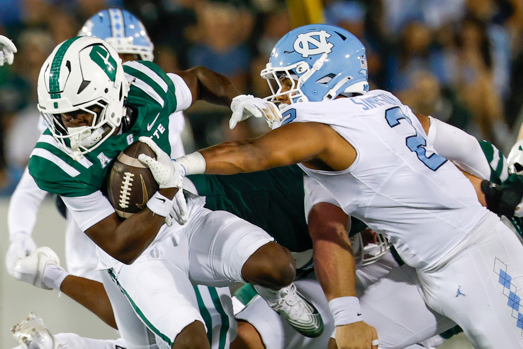Charlotte running back Rod Gainey Jr., left, rushes the ball against North Carolina linebacker Andrew Simpson (2) during the first half of an NCAA college football game in Charlotte, N.C., Saturday, Sept. 6, 2025. (AP Photo/Nell Redmond)