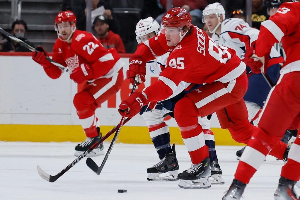 Detroit Red Wings left wing Elmer Soderblom (85) moves the puck past Washington Capitals center Nic Dowd during the first period of an NHL hockey game Thursday, Jan. 29, 2026, in Detroit. (AP Photo/Duane Burleson)