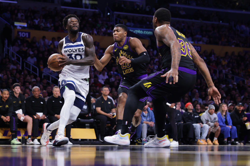 Minnesota Timberwolves forward Julius Randle (30) drives the ball against Los Angeles Lakers forward Rui Hachimura (28) and guard Marcus Smart (36) during the first half of an NBA basketball game, Tuesday, March 10, 2026, in Los Angeles. (AP Photo/Ethan Swope)