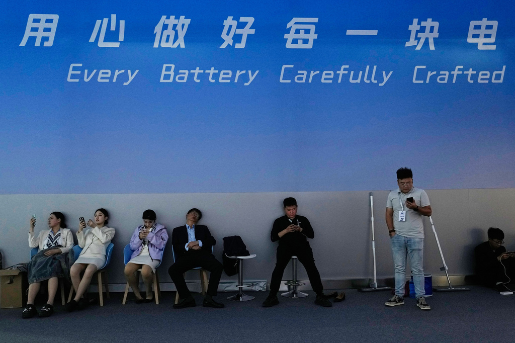 Workers rest at the backstage of a booth promoting batteries for EV cars at the Auto China 2026, in Beijing, Friday, April 24, 2026. (AP Photo/Andy Wong)