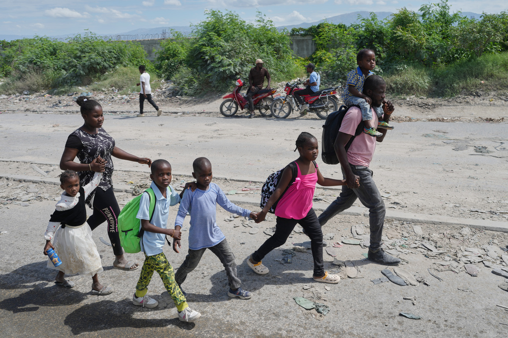 Residents flee their homes to escape clashes between armed gangs in Port-au-Prince, Haiti, Monday, May 11, 2026. (AP Photo/Odelyn Joseph)
