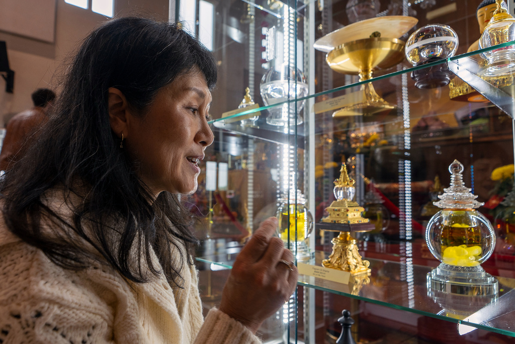 Buddhist practitioner and disciple of Master YongHua, Sarah Kim, shows the Fragrant Oil Shariras among other Buddhist relics displayed at Wei Mountain Temple, in Rosemead, Calif., Saturday, Feb. 17, 2024. (AP Photo/Damian Dovarganes)