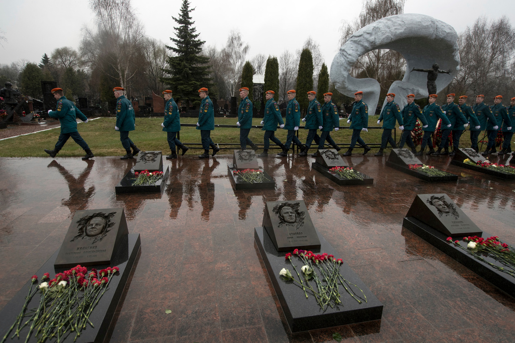FILE - Russian Emergency Ministry troops march at Mitinskoye Cemetery in Moscow, Russia, on Thursday, April 26, 2018, the 32nd anniversary of the explosion and fire at the Chernobyl nuclear power plant in Ukraine. Several victims of the disaster are buried in the cemetery. (AP Photo/Pavel Golovkin, File)
