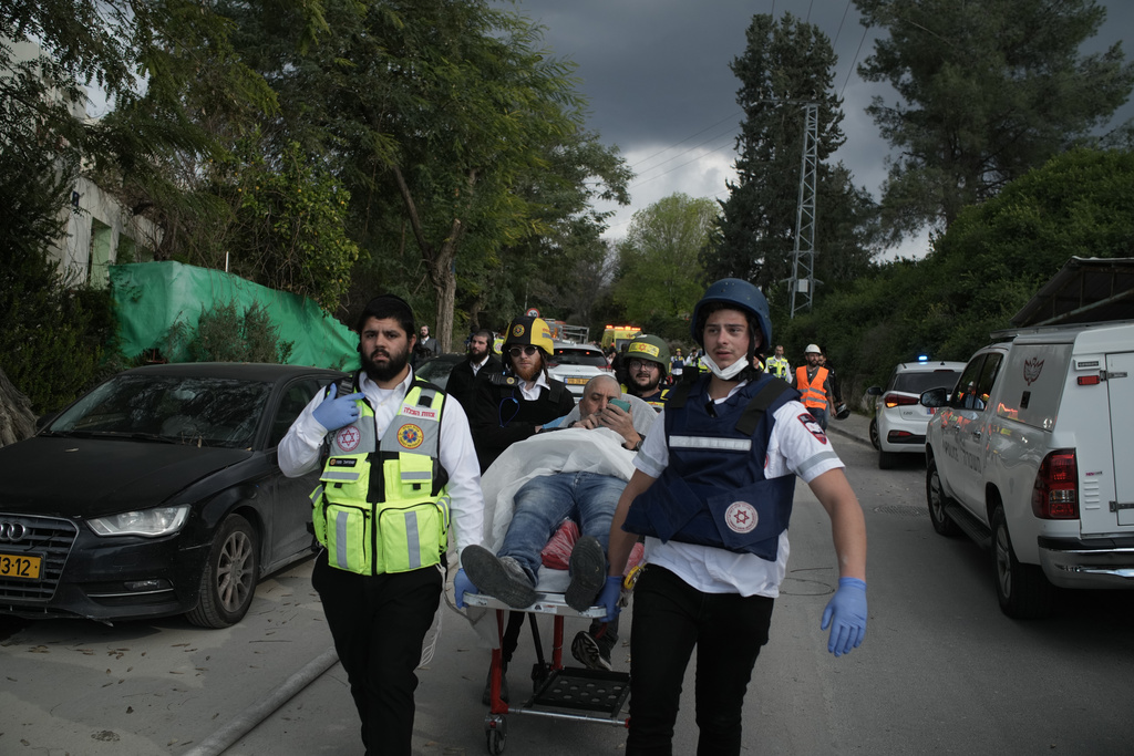 Paramedics evacuate wounded people from the site of a deadly Iranian missile strike in Beit Shemesh, Israel Sunday, March 1, 2026. (AP Photo/Leo Correa)