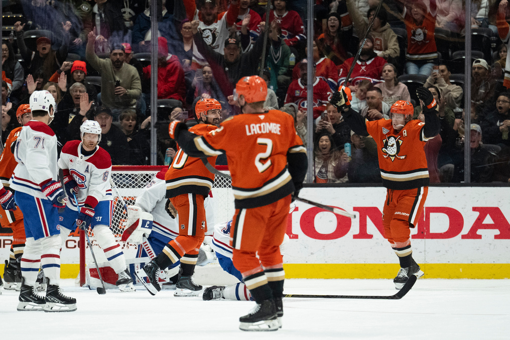 Anaheim Ducks center Leo Carlsson, right, and left wing Chris Kreider, center left, react after a goal by defenseman Jackson LaCombe (2) during the second period of an NHL hockey game against the Montreal Canadiens, Friday, March 6, 2026, in Anaheim, Calif. (AP Photo/Kyusung Gong)