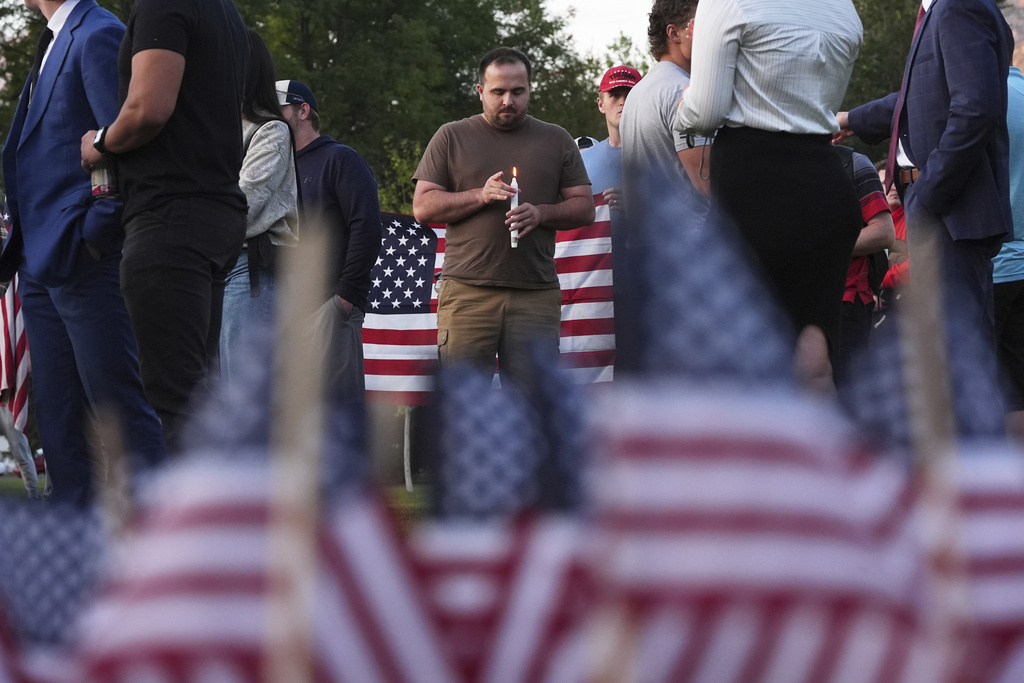 A man holds a candle as attendees pay their respects during a vigil for Charlie Kirk on Friday, Sept. 12, 2025, in Provo, Utah. (AP Photo/Lindsey Wasson)