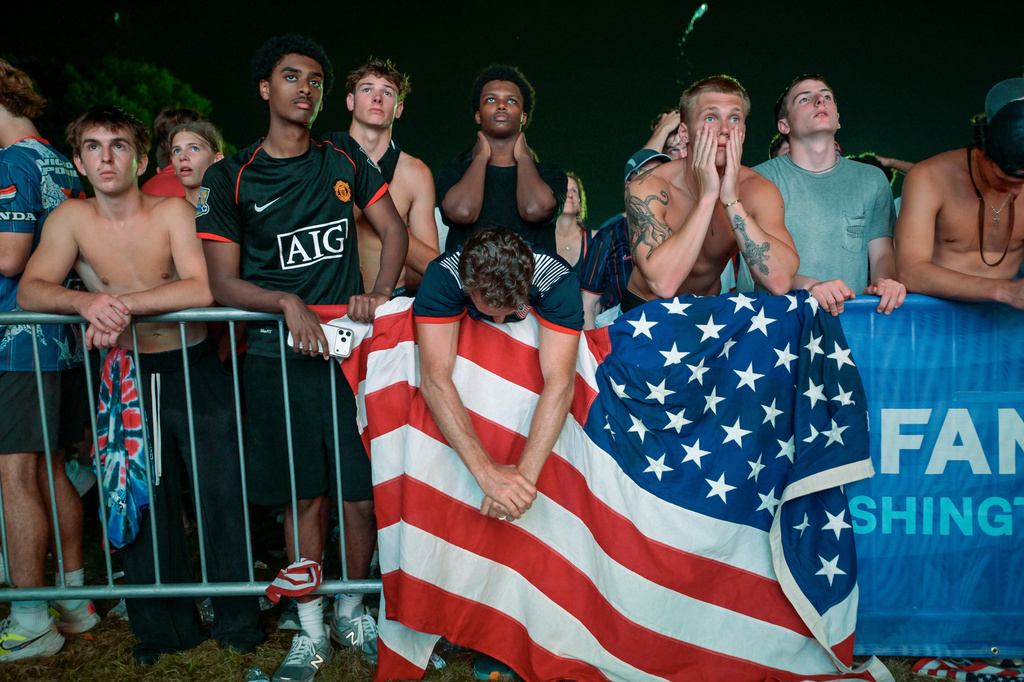 John TenBrink, center left, and his son Dylan TenBrink, center right, react as the United States loses a World Cup round of 16 soccer match to Belgium, during a watch party, Monday, July 6, 2026, in Washington, at the FIFA Fan Zone on the National Mall. (AP Photo/Rod Lamkey, Jr.)