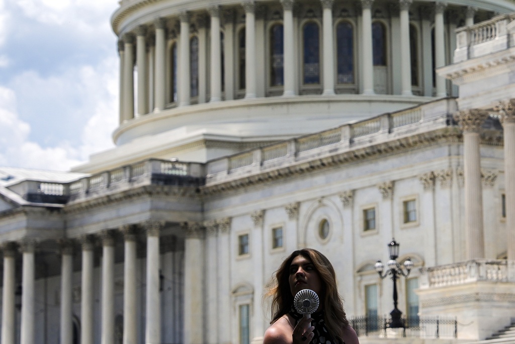 FILE - A woman uses a portable fan to cool down June 25, 2025, outside the U.S. Capitol in Washington. (AP Photo/Julia Demaree Nikhinson, File)