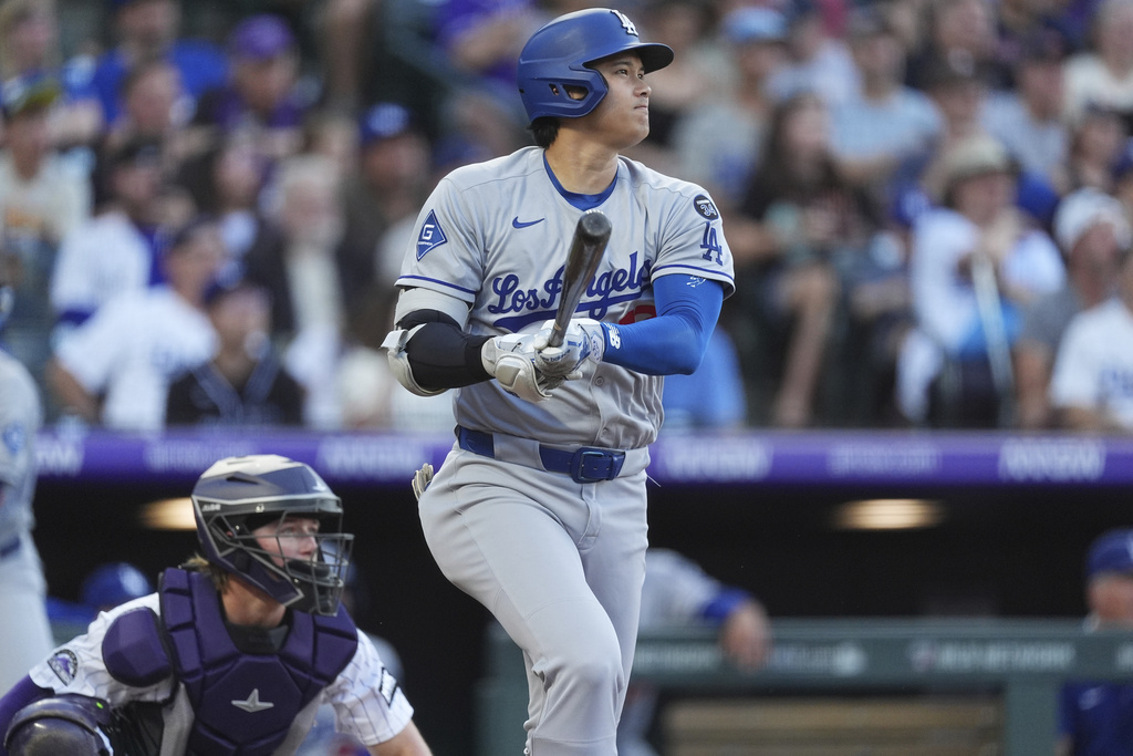 Los Angeles Dodgers' Shohei Ohtani follows the flight of his solo home run off Colorado Rockies pitcher Austin Gomber in the second inning of a baseball game Tuesday, Aug. 19, 2025, in Denver. (AP Photo/David Zalubowski)