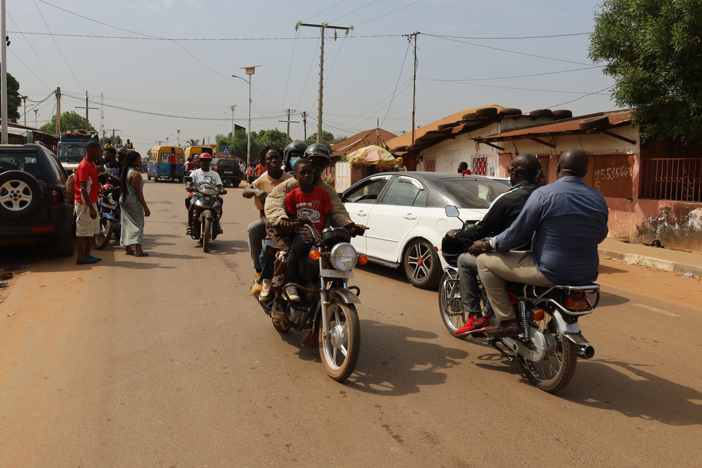 People ride on motorcycle taxis on the street in Bissau, Guinea-Bissau, Wednesday, Nov. 26, 2025. (AP Photo/Darcicio Barbosa)