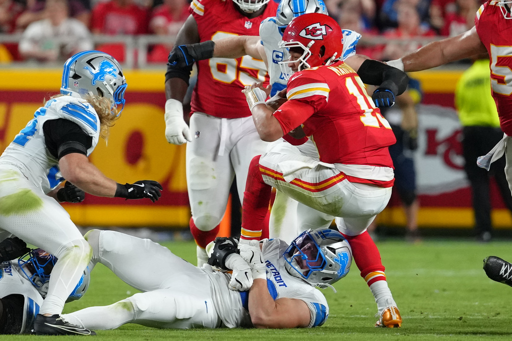 Kansas City Chiefs quarterback Patrick Mahomes, top, struggles for yardage as Detroit Lions linebacker Trevor Nowaske defends during the second half of an NFL football game Sunday, Oct. 12, 2025, in Kansas City, Mo. (AP Photo/Ed Zurga)