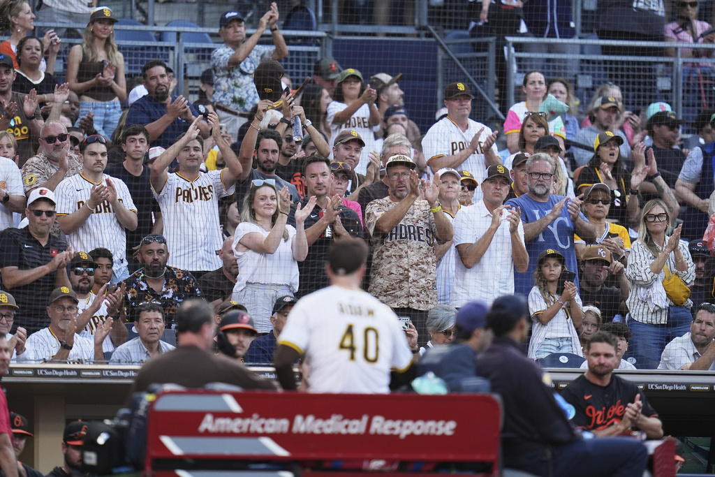 Fans applaud as San Diego Padres relief pitcher Jason Adam leaves in a cart after falling with an injury during the seventh inning of a baseball game against the Baltimore Orioles Monday, Sept. 1, 2025, in San Diego. (AP Photo/Gregory Bull)