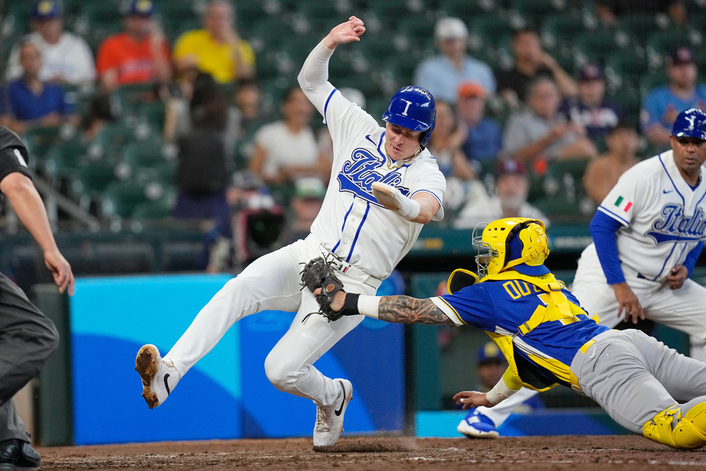 Italy's Zach Dezenzo, left, is tagged out at home plate by Brazil catcher Gabriel Do Carmo during the sixth inning of a World Baseball Classic game, Saturday, March 7, 2026, in Houston. (AP Photo/David J. Phillip)