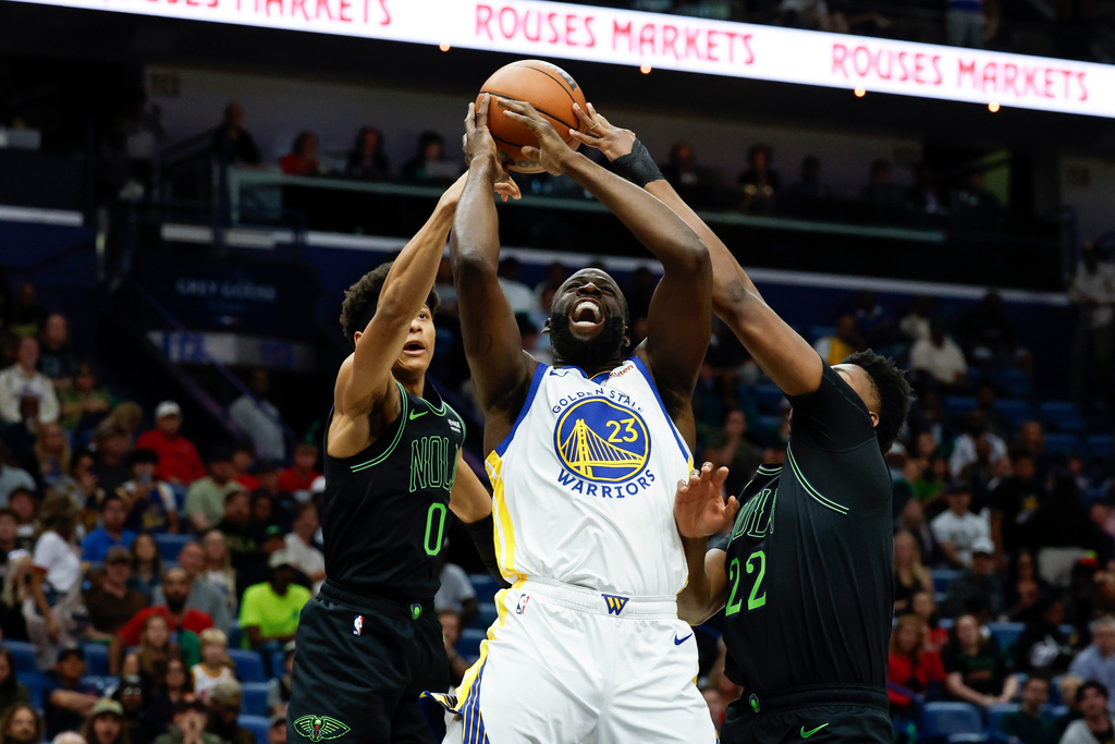 New Orleans Pelicans center Derik Queen (22) and guard Jeremiah Fears (0) strip the ball from Golden State Warriors forward Draymond Green (23) as he goes to the basket during the first quarter of an NBA basketball game, Sunday, Nov. 16, 2025, in New Orleans. (AP Photo/Butch Dill)