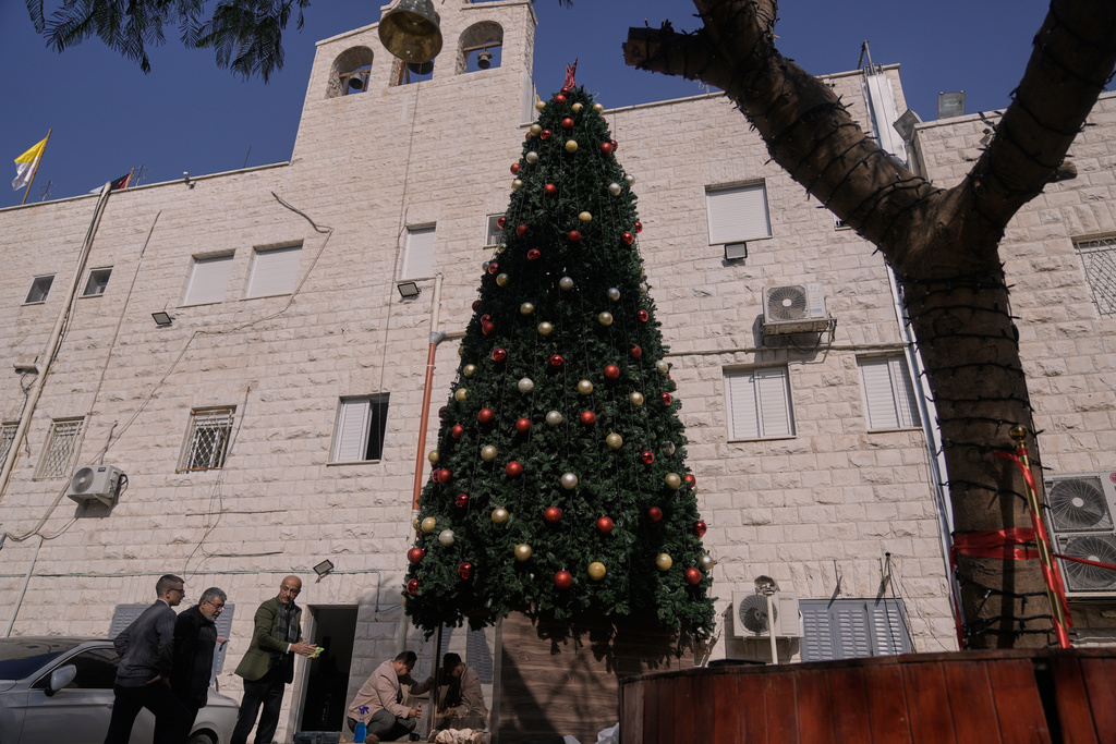 Palestinian parishioners check a recently installed Christmas tree after the previous one was destroyed at the Holy Redeemer Latin Church in the West Bank town of Jenin, Tuesday, Dec. 23, 2025. (AP Photo/Majdi Mohammed)