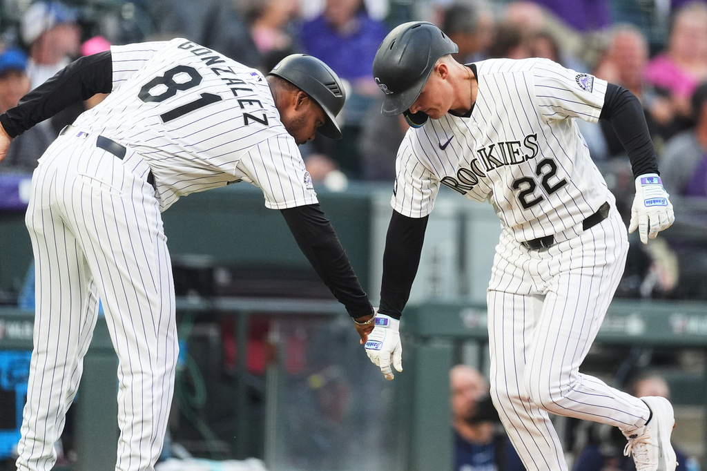 Colorado Rockies third base coach Andy Gonz·lez, left, congratulates Mickey Moniak as he circles the bases after hitting a three-run home run off Tampa Bay Rays starting pitcher Freddy Peralta in the third inning of a baseball game Tuesday, Aug. 4, 2026, in Denver. (AP Photo/David Zalubowski)