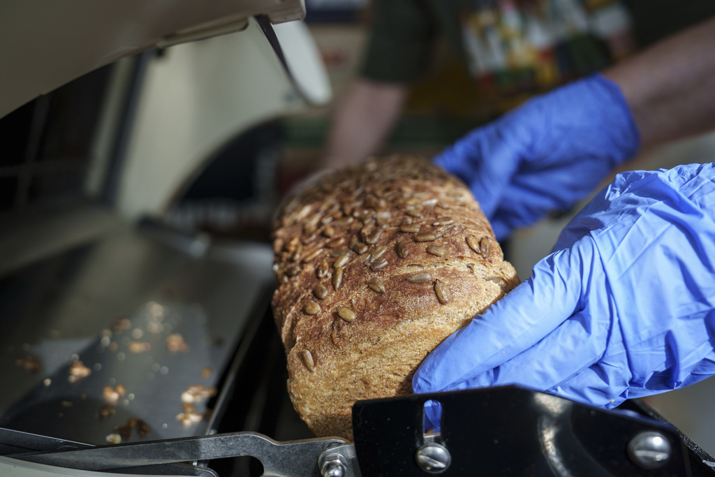 Volunteers slice bread from Community Loaves at the Edmonds Food Bank in Edmonds, Wash., Monday, Sept. 8, 2025. (AP Photo/Annika Hammerschlag)