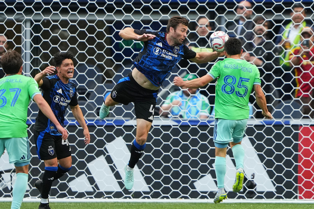San Jose Earthquakes defender Dave Romney, center, commits a handball against a shot from Seattle Sounders midfielder Kalani Kossa-Rienzi (85), leading to a penalty kick and a goal for the Sounders, during the first half of an MLS soccer match, Wednesday, May 13, 2026, in Seattle. (AP Photo/Lindsey Wasson)
