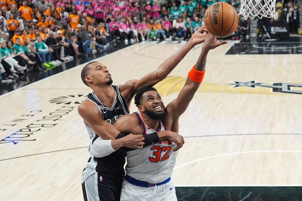 San Antonio Spurs forward Victor Wembanyama and New York Knicks center Karl-Anthony Towns (32) battle for the rebound during the second half of Game 1 of the NBA Finals basketball series, Wednesday, June 3, 2026, in San Antonio. (AP Photo/Eric Gay)