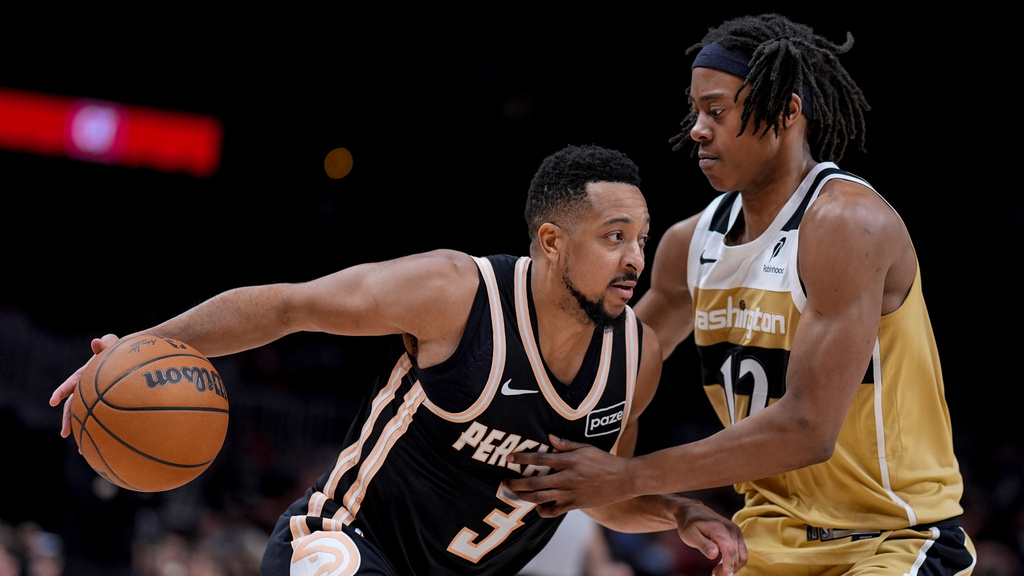 Atlanta Hawks guard CJ McCollum (3) drives against Washington Wizards guard Tre Johnson (12) during the first half of an NBA basketball game, Thursday, Feb. 26, 2026, in Atlanta. (AP Photo/Mike Stewart)