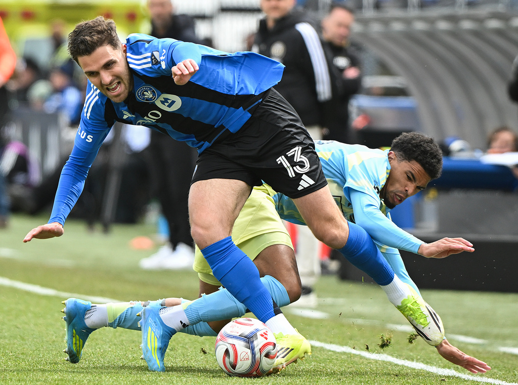 CF Montreal's Luca Petrasso (13) gets by Philadelphia Union's Nathan Harriel (26) during the first half of an MLS soccer game in Montreal, Saturday, April 11, 2026. (Graham Hughes/The Canadian Press via AP)