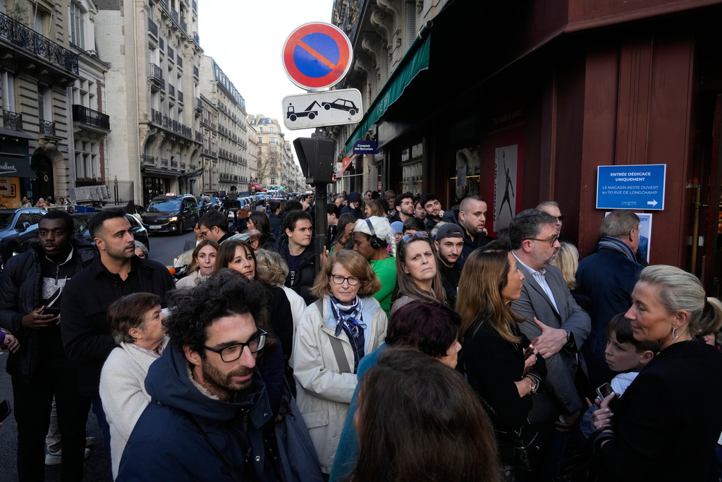 People queue as they arrive to buy the book of former French President Nicolas Sarkozy "Diary of a Prisoner," in a Paris bookshop, Wednesday, Dec. 10, 2025. (AP Photo/Michel Euler)