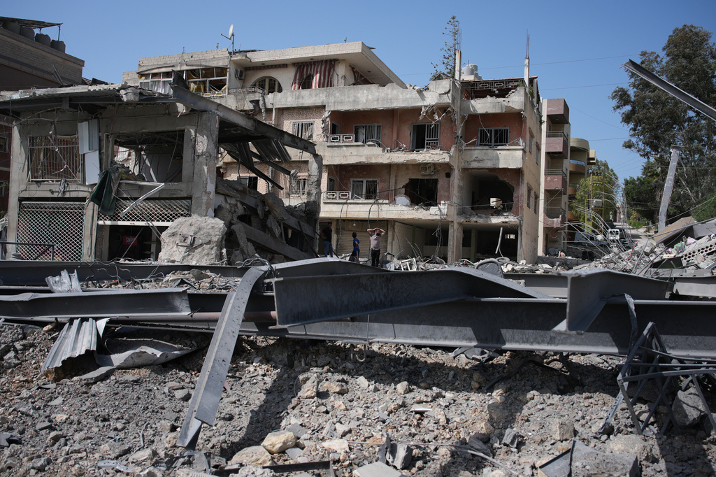 Residents inspect damage at the site of buildings destroyed in Israeli airstrikes, in Jibchit, southern Lebanon, Friday, April 17, 2026, following a ceasefire between Israel and Hezbollah. (AP Photo/Hassan Ammar)