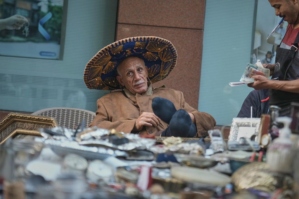 A vendor wearing a Mexican sombrero waits for customers at his stall at the Diana Antiques Market, a weekly market for antiques and vintage goods in downtown Cairo, Egypt, Saturday, Oct. 17, 2026. (AP Photo/Amr Nabil)