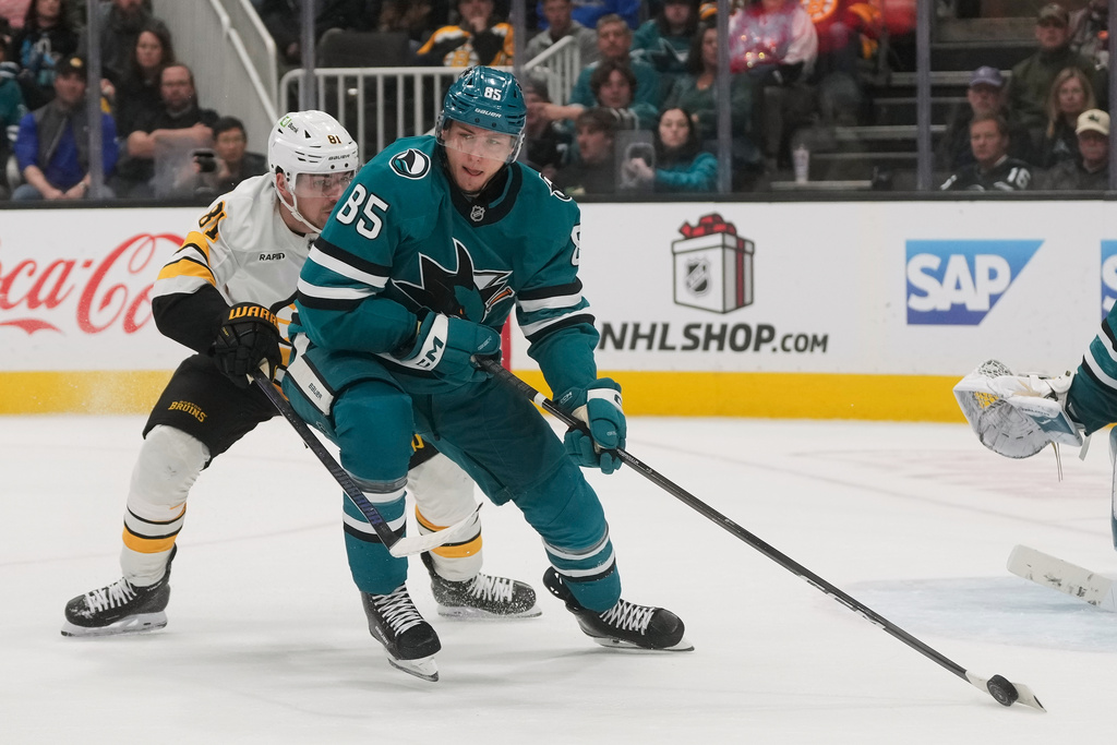 San Jose Sharks defenseman Shakir Mukhamadullin (85) passes the puck in front of Boston Bruins center Michael Eyssimont (81) during the second period of an NHL hockey game in San Jose, Calif., Sunday, Nov. 23, 2025. (AP Photo/Jeff Chiu)