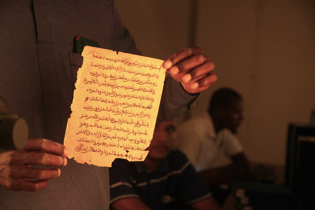 An employee displays a manuscript at the Ahmed Baba Institute of Higher Islamic Studies and Research in Timbuktu, Mali, Sept. 4, 2025. (AP Photo/Baba Ahmed)