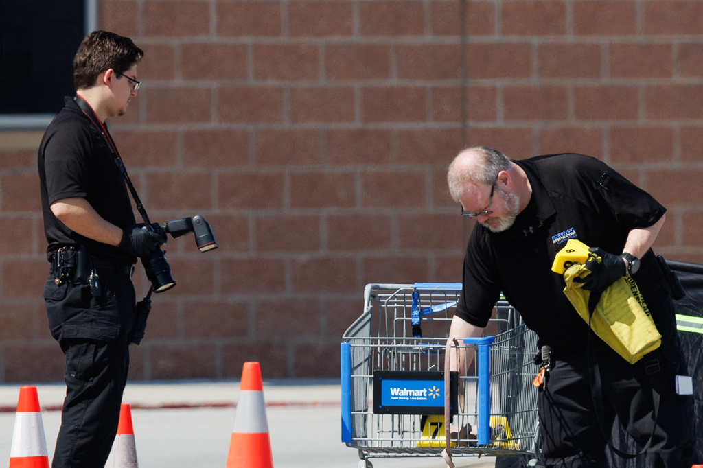 Omaha police work outside a Walmart store at South 72nd and Pine Streets in Omaha, Neb., on Tuesday, April 14, 2026, after police fatally shot a woman who was accused of cutting a young child's face with a knife. (Nikos Frazier/Omaha World-Herald via AP)