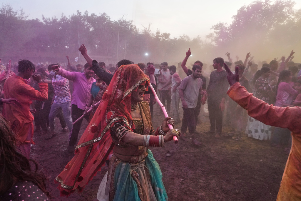 A member of transgender community shoos away revelers as she dances during Holi festival celebrations at the Shri Krishna Janmabhoomi Temple complex in Mathura, India, on Feb. 27, 2026. (AP Photo/Manish Swarup)